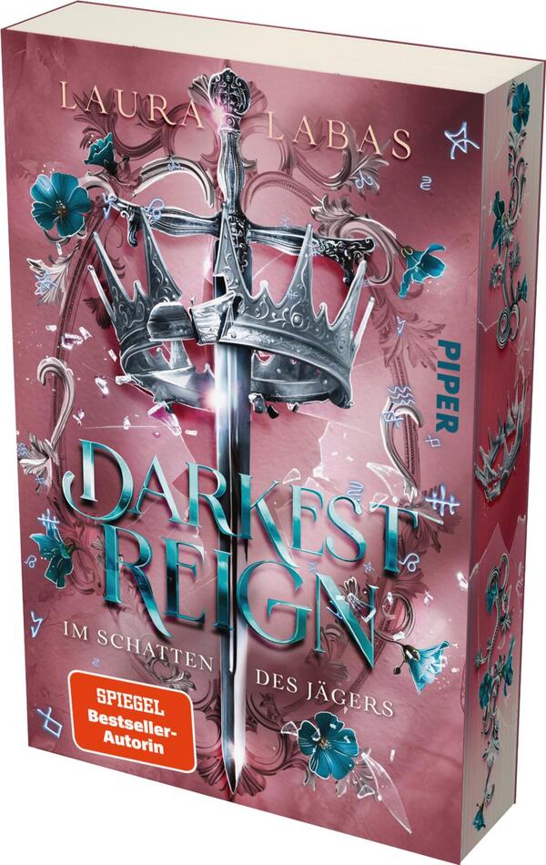 Das Buchcover zeigt einen blassen, rosafarbenen Hintergrund, der von filigranen, blauen und grünen Blumenmotiven durchzogen ist. In der Mitte befindet sich ein schimmerndes Schwert, das von einer prächtigen Krone umgeben ist. Der Titel „DARKEST REIGN“ hebt sich in großen, türkisfarbenen Buchstaben hervor, während der Untertitel „IM SCHATTEN DES JÄGERS“ in kleineren, eleganten Schriftzügen dargestellt ist. Oben ist der Name der Autorin, „Laura Labas“, platziert. Ein rotes Kästchen mit dem Text „SPIEGEL-Bestseller-Autorin“ ergänzt das Cover.
