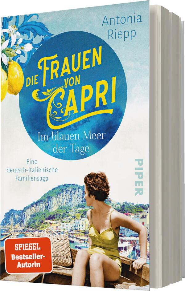 Das Buchcover zeigt eine junge Frau in einem hellen, schulterfreien Kleid, die auf einen atemberaubenden Ausblick über das blaue Meer schaut. Im Hintergrund sind die charakteristischen Klippen und Gebäude von Capri zu sehen. Der Titel „Die Frauen von Capri“ ist in großen, geschwungenen, gelben Buchstaben platziert, der Untertitel „Im blauen Meer der Tage“ in einer kleineren Schriftart darunter. Die Farben sind lebhaft und vermitteln ein Gefühl von Sommer und Urlaub. Die Autorin Antonia Riepp wird ebenfalls prominent erwähnt.