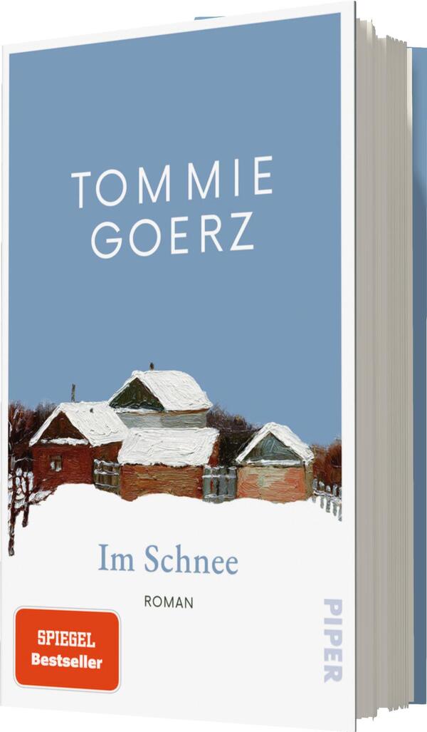 Das Buchcover zeigt eine winterliche Landschaft mit schneebedeckten Häusern in sanften Farben. Der Himmel ist hellblau, was eine ruhige Atmosphäre vermittelt. Der Titel „Im Schnee“ ist in einer klaren, weißen Schrift platziert, während der Autorenname „Tommie Goerz“ prominent oben steht. Am unteren Rand befindet sich die Bezeichnung „Roman“ in kleinerer Schrift. Ein rotes Emblem mit der Aufschrift „SPIEGEL Bestseller“ hebt die Beliebtheit des Buches hervor.
