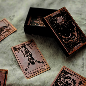 Tarotkarten und eine dazugehörige Box liegen auf einer hellen, flauschigen Unterlage.