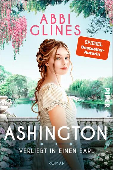 Das Buchcover zeigt eine junge Frau mit langen, gewellten Haaren, die in einem romantischen Garten steht. Sie trägt ein helles, schlichtes Kleid und blickt direkt in die Kamera. Im Hintergrund sind üppige Pflanzen und blühende Bäume zu sehen, die eine idyllische Atmosphäre schaffen. Der Titel „ASHINGTON – Verliebt in einen Earl“ erscheint in großen, weißen Buchstaben am unteren Rand. Oben steht „ABBI GLINES“ in rosa und der Hinweis „SPIEGEL Bestseller-Autorin“ in einer orangefarbenen Box.