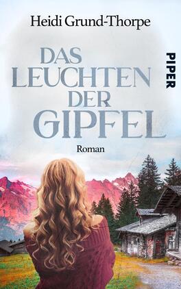 Das Buchcover zeigt eine Frau mit long, lockigem Haar, die mit dem Rücken zur Kamera steht. Der Hintergrund zeigt majestätische, rot-rosa gefärbte Berge unter einem sanften Himmel. Im Vordergrund ist eine traditionelle alpine Hütte abgebildet. Der Titel „DAS LEUCHTEN DER GIPFEL“ ist in großen, eleganten Buchstaben platziert, darüber steht der Name der Autorin „Heidi Grund-Thorpe“ in einer schlichten Schriftart. Der Verlag „PIPER“ ist in der oberen rechten Ecke angebracht. Die Farben sind harmonisch und verleihen dem Cover eine verträumte Atmosphäre.