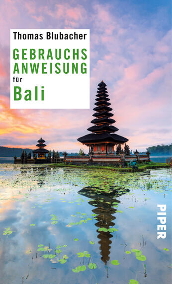 Das Buchcover zeigt eine atemberaubende Landschaftszene von Bali mit einem traditionellen Tempel im Vordergrund, der sich majestätisch über das Wasser erhebt. Der Himmel ist bei Sonnenaufgang in sanften Rosa-, Blau- und Violetttönen gefärbt. Der Titel „GEBRAUCHSANWEISUNG für Bali“ steht in grüner Schrift oben links, während der Name des Autors, Thomas Blubacher, in kleinerer Schrift darüber platziert ist. Der Verlag „PIPER“ ist rechts im Cover in Weiß angegeben.