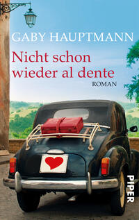 Das Buchcover zeigt ein nostalgisches Auto von hinten, beladen mit einem roten Koffer, vor einer malerischen Landschaft mit sanften Hügeln und einer blauen Himmelspanne. Oben links steht in eleganter Schrift „GABY HAUPTMANN“, darunter in auffälligen, dunkelroten Buchstaben „Nicht schon wieder al dente“. Der Schriftzug „ROMAN“ ist klein und dezent gehalten. Die Atmosphäre des Covers vermittelt ein Gefühl von Abenteuer und Fernweh, verstärkt durch die harmonische Farbgebung und die ländliche Kulisse.
