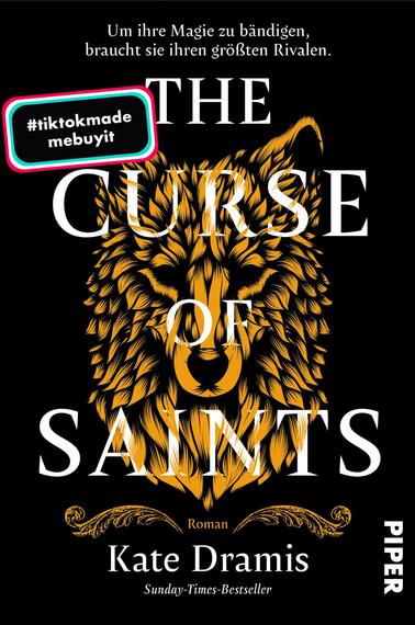 Das Buchcover zeigt einen schwarzen Hintergrund, auf dem ein goldfarbenes, stilisiertesWolfskopf-Design im Mittelpunkt steht. Darüber steht in großen, eleganten Buchstaben „THE CURSE OF SAINTS“. Der Authorenname „Kate Dramis“ ist in kleinerer Schrift unter dem Titel platziert. Ein Hinweis in einem farbigen Kasten besagt „#tiktokmade mebuyit“. Die Gesamtatmosphäre des Covers vermittelt einen mystischen und kraftvollen Eindruck.