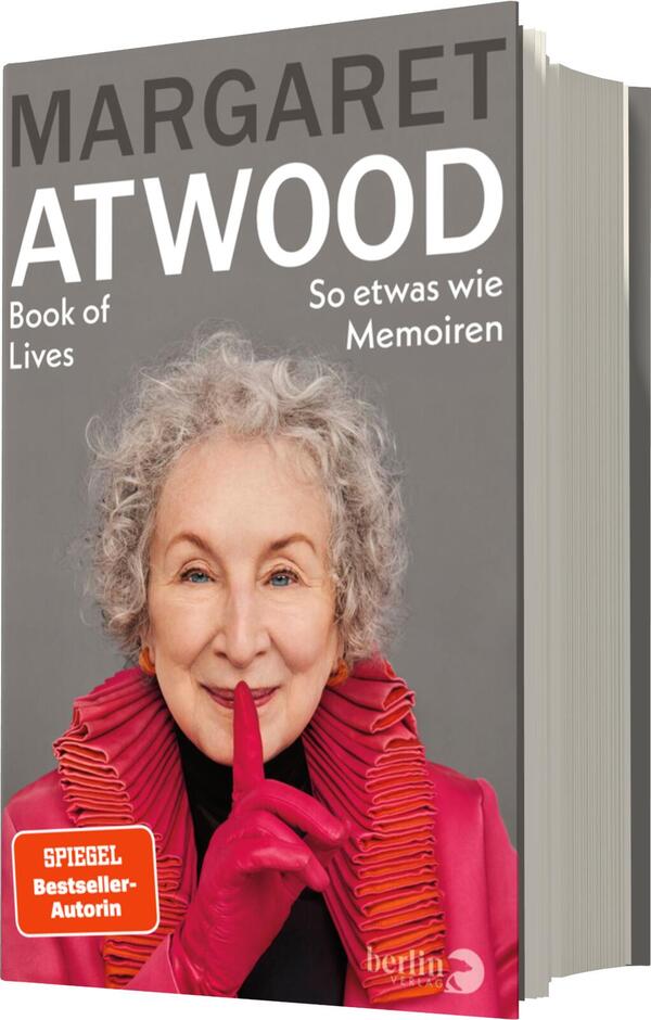 Das Buchcover zeigt ein Portrait von Margaret Atwood, die lächelnd in die Kamera blickt. Sie trägt ein helles Oberteil und auffällige, rote Handschuhe. Der Hintergrund ist schlicht und hell gehalten. Oben auf dem Cover steht in Großbuchstaben „MARGARET ATWOOD“, darunter der Titel „Book of Lives“ in kleinerer, eleganter Schrift. Am unteren Rand ist der Untertitel „So etwas wie Memoiren“ zu sehen. Ein Hinweis auf „SPIEGEL Bestseller-Autorin“ befindet sich ebenfalls auf dem Cover.