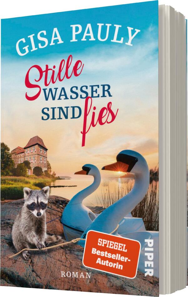 Das Buchcover zeigt eine idyllische Landschaft mit einem ruhigen Gewässer im Vordergrund. Zwei stilisierte Schwäne schwimmen sanft auf dem Wasser. Ein Waschbär sitzt am Ufer und schaut neugierig in die Richtung des Betrachters. Im Hintergrund ist ein altes, charmantes Gebäude in warmen Farben zu sehen. Der Titel „Stille Wasser sind fies“ ist in auffällig roter Schrift gestaltet, während der Autorennamen „Gisa Pauly“ darüber in geschwungener, blauer Typografie steht. Die Atmosphäre wirkt friedlich und gleichzeitig mysteriös.