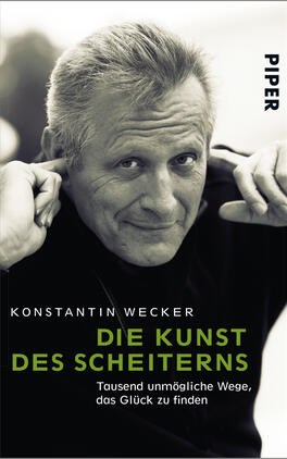 Das Buchcover zeigt ein Schwarz-Weiß-Porträt von einem lächelnden Mann mit grauen Haaren und einem nachdenklichen Blick. Er hält eine Hand an sein Kinn, während er leicht zur Seite schaut. Der Buchtitel „DIE KUNST DES SCHEITERN“ ist in großen, grünen Buchstaben unterhalb des Portraits platziert. Darunter steht der Untertitel „Tausend unmögliche Wege, das Glück zu finden“ in kleinerer, weißer Schrift. Der Name des Autors „KONSTANTIN WECKER“ ist oberhalb des Porträts zu sehen. Die Atmosphäre wirkt nachdenklich und inspirierend.