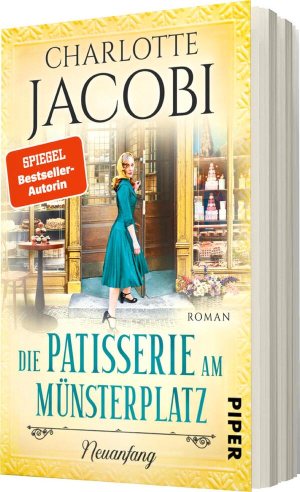 Das Buchcover zeigt eine blonde Frau in einem eleganten, türkisfarbenen Kleid, die vor einer Patisserie steht. Die storefront ist reich dekoriert, mit vielen bunten Torten und Gebäck. Im oberen Bereich steht der Name „Charlotte Jacobi“ in stilvoller, schwarzer Schrift. Darunter sind die Worte „Die Patisserie am Münsterplatz“ in auffälligem Blau zu sehen, sowie der Zusatz „Roman“. Ein rotes Label mit der Aufschrift „SPIEGEL-Bestseller-Autorin“ hebt sich deutlich ab. Die sanften, hellen Farben verleihen dem Cover eine freundliche, einladende Atmosphäre.