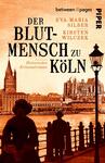Das Buchcover zeigt eine historische Stadtansicht von Köln in warmen, orangeroten Tönen. Im Vordergrund sind Silhouetten von zwei Personen zu sehen, eine im Profil mit Hut, die andere mit einem auffälligen Kleid. Im Hintergrund ragt der Kölner Dom über die Häuser hinweg. In großen, schwarzen Buchstaben steht „DER BLUTMENSCH ZU KÖLN“ prominent über dem Bild. Untertitel und Autorennamen sind in kleineren, schwarzen Schriftzügen oberhalb und unterhalb der Titelschrift platziert.