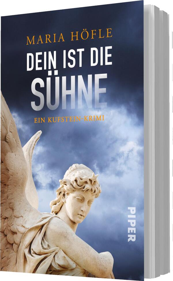 Das Buchcover zeigt eine dramatische Wolkenlandschaft in dunklen Blau- und Grautönen. Im Vordergrund ist eine detailreiche Statue eines Engels zu sehen, der nachdenklich in die Ferne blickt. Der Titel „DEIN IST DIE SÜHNE“ steht in großen, weißen Lettern, während die Autorin Maria Höfle darüber in goldener Schrift platziert ist. Am unteren Rand befindet sich der Zusatz „Ein Kufstein-Krimi“ in schlichter, weißer Schrift. Das Cover vermittelt eine geheimnisvolle und spannende Atmosphäre.