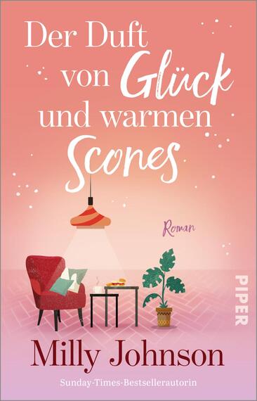 Das Buchcover zeigt den Titel „Der Duft von Glück und warmen Scones“ auf einem warmen Rosa‑Korall‑Verlauf mit kleinen weißen Funkelpunkten. Die Wörter „Glück“ und „Scones“ sind in weißer, handschriftlicher Script‑Typografie, der Rest in eleganter Serifenschrift. Unten ein roter Sessel mit grünem Kissen, hängende Lampe, Tisch mit Teller Scones und eine Topfpflanze; die Szene wirkt gemütlich und heimelig. Autorin: Milly Johnson.