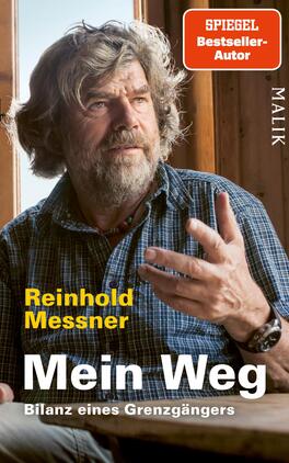 Das Buchcover zeigt Reinhold Messner in einem natürlichen Licht, während er in einem Holzraum sitzt. Sein ausdrucksvolles Gesicht und der leicht nachdenkliche Blick verstärken die persönliche Atmosphäre. Er trägt ein karierter Hemd und zeigt mit der Hand eine gestische Geste. Der Titel „Mein Weg“ ist in großer, gelber Schrift hervorgehoben, gefolgt von dem Untertitel „Bilanz eines Grenzgängers“. Oben rechts befindet sich ein rotes Quadrat mit der Aufschrift „SPIEGEL Bestseller-Autor“. Die Gestaltung vermittelt eine Mischung aus Authentizität und Reflexion.
