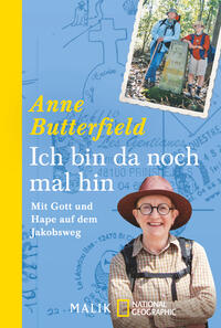 Das Buchcover zeigt einen hellblauen Hintergrund mit schematischen Kartenmotiven. Oben links steht der Name „Anne Butterfield“ in einer gelben Schrift, gefolgt vom Titel „Ich bin da noch mal hin“ in großer, weißer Schrift. Darunter befindet sich der Untertitel „Mit Gott und Hape auf dem Jakobsweg“ in kleiner, schwarzer Schrift. In der Mitte sind zwei Wanderer abgebildet, die in Outdoor-Bekleidung stehen und an einem Wegweiser posieren. Die Szene vermittelt ein Gefühl von Abenteuer und Erkundung.