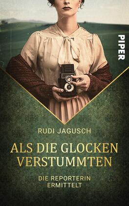 Das Buchcover zeigt eine Frau mit einem vintage Fotografiegerät, die direkt in die Kamera blickt. Sie trägt ein elegantes, helles Kleid und hat eine nostalgische Frisur. Der Hintergrund ist in gedeckten Grüntönen gehalten und vermittelt eine historische Atmosphäre. Der Titel „Als die Glocken verstummten“ steht in goldener Schrift unter dem Autorennamen Rudi Jagusch. Unter dem Titel befindet sich der Zusatz „Die Reporterin ermittelt“ in kleinerer, ebenfalls goldener Schrift.