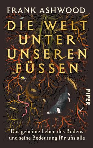 Das Buchcover zeigt vor dunkelbraunem Hintergrund ein dichtes Geflecht aus Wurzeln in Orange-, Gelb- und Grüntönen, dazwischen Regenwürmer, ein Tausendfüßler und ein grau-schwarzer Maulwurf. Der Titel „Die Welt unter unseren Füßen“ steht in großer goldgelber Serifenschrift zentriert; oben der Autorenname „Frank Ashwood“ in weißen Großbuchstaben, unten der weiße Untertitel „Das geheime Leben des Bodens und seine Bedeutung für uns alle“. Die Atmosphäre wirkt geheimnisvoll und organisch.