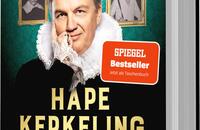Das Buchcover zeigt Hape Kerkeling in historischem Kostüm mit weißem Kragen und freundlichem Gesichtsausdruck. Im Hintergrund sind mehrere schwarz-weiß Porträts in goldenen Rahmen angeordnet. Die Farben des Covers sind überwiegend grün und schwarz, mit goldenen Schriftzügen. Der Titel „Gebt mir etwas Zeit“ und der Autorname „Hape Kerkeling“ sind prominent platziert. Ein roter Aufkleber mit dem Text „SPIEGEL Bestseller – Jetzt als Taschenbuch“ ist in der oberen rechten Ecke sichtbar.