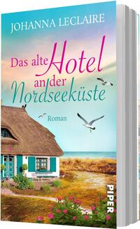 Das Buchcover zeigt ein reetgedecktes Küstenhaus links im Vordergrund, davor bunte Blumen und Dünen mit Gras, im Hintergrund ruhiges Meer und ein pastellfarbener Himmel in Rosa, Türkis und Hellgelb. Drei Möwen fliegen über dem Wasser. Die Titelschrift kombiniert eine große, pinke Kursivschrift für „Hotel“ mit türkis‑ und rosafarbenen Serifbuchstaben für „Das alte Hotel an der Nordseeküste“, oben in Weiß: Johanna Leclaire; unten kleingedruckt: „Roman“.