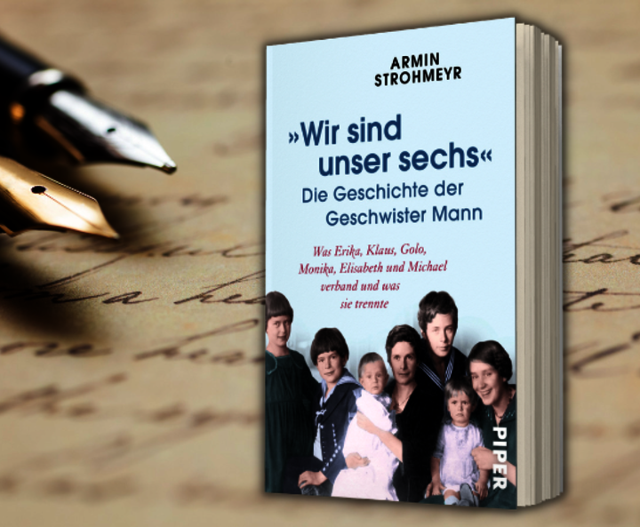 Armin Strohmeyrs „Wir sind unser sechs“ zu sehen vor handschriftlichem Text mit zwei Füllern