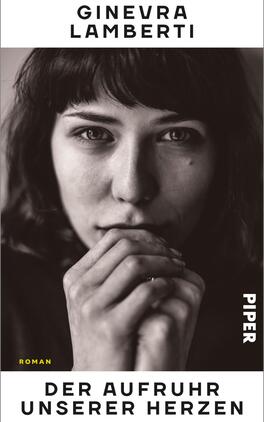 Das Buchcover zeigt ein schwarz-weißes Porträt einer jungen Frau mit dunklen Haaren, die nachdenklich die Hände vor dem Gesicht hält. Der Hintergrund ist neutral, wodurch der Fokus auf dem Ausdruck der Protagonistin liegt. Der Titel „DER AUFTRUHR UNSERER HERZEN“ ist in großer, gelber Schrift platziert, unterhalb steht der Name der Autorin „GINEVRA LAMBERTI“ in schwarzer Schrift. Im unteren Bereich befindet sich das Wort „ROMAN“ in weißer Schrift, und der Verlagsname „PIPER“ ist vertikal in weißer Schrift am rechten Rand angebracht.