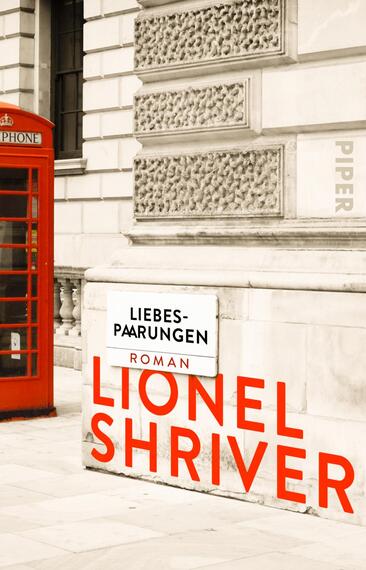 Das Buchcover zeigt eine stilisierte Außenansicht eines Gebäudes mit einer auffälligen roten Telefonzelle im Vordergrund. Der Schriftzug „LIEBES-PAARINGEN“ ist in eleganter, grauer Typografie auf einem weißen Schild platziert, darunter steht in kräftigen roten Buchstaben der Name „LIONEL SHRIVER“. Die Farben des Covers sind überwiegend in Grautönen gehalten, mit dem starken Kontrast von Rot, was eine lebendige und ansprechende Atmosphäre schafft.