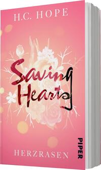 Das Buchcover zeigt einen zarten pinkfarbenen Hintergrund, der mit verschwommenen, floralen Mustern verziert ist. Im Vordergrund steht der Titel „Saving Hearts“ in einer künstlerischen Typografie, wobei „Hearts“ in einer kräftigen, rot-transparenten Schrift gestaltet ist. Unter dem Titel ist der Untertitel „HERZRASEN“ in einer schlichten, schwarzen Schrift platziert. Oben links ist der Name der Autorin „H.C. HOPE“ in einer eleganten, weißen Schrift sichtbar.
