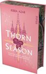 Das Buchcover zeigt einen sanften rosafarbenen Hintergrund. Zentral platziert ist der Titel „THORN SEASON“ in großen, weißen Buchstaben, umgeben von zarten, stilisierten Rosen in tiefem Rot. Über dem Titel erstrecken sich strahlende goldene Linien und Symbole, die Spannung und Magie vermitteln. Am oberen Rand befindet sich der Name der Autorin, Kiera Azar, in eleganter Schrift. Unter dem Titel steht der Satz „Sie ist von Jägern umzingelt, doch ihr Herz wird kämpfen“ in klarer, schmaler Schrift.