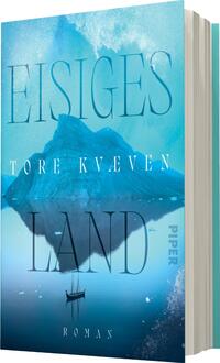 Das Buchcover zeigt eine kühle, eisige Landschaft in sanften Blautönen. Im Vordergrund spiegelt sich ein großes, schneebedecktes Gebirge im Wasser. Ein kleineres Boot mit einer Person ist in der unteren Bildhälfte sichtbar. Der Titel „EISIGES LAND“ sowie der Autor „TORE KVÆVEN“ sind in eleganter, serifenloser Typografie in hellblau und weiß gehalten. Der Verweis „ROMAN“ ist dezenter platziert. Die Gesamtatmosphäre vermittelt ein Gefühl von Kälte und Einsamkeit.