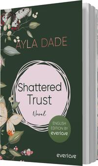 Das Buchcover zeigt einen dunkelgrünen Hintergrund, auf dem zarte Pflanzen und Schmetterlinge in sanften Farben platziert sind. Im Zentrum befindet sich ein rosafarbener Kreis, der den Titel „Shattered Trust“ in dunkler Schrift präsentiert. Darunter steht das Wort „Novel“. Oben links ist der Name der Autorin „Äyla Dade“ in einer eleganten Schriftart geschrieben. Unten rechts befindet sich ein runder Button mit dem Text „ENGLISH EDITION BY everlove“.