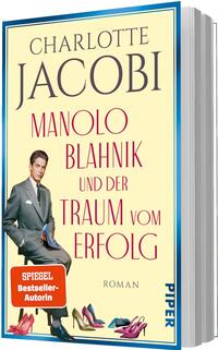 Das Buchcover zeigt einen cremefarbenen Hintergrund mit großem blauen Autorennamen „CHARLOTTE JACOBI“ oben und dem roten Titel „MANOLO BLAHNIK und der Traum vom Erfolg“ darunter. Im Vordergrund ein blauer, hochhackiger Damenschuh mit funkelnder Verzierung; rechts ein Mann im grauen Anzug, der einen Schuh in der Hand präsentiert. Unten links ein oranger quadratischer Button mit weißer Aufschrift „SPIEGEL Bestseller-Autorin“. Kleiner Hinweis „ROMAN“ unter dem Titel.