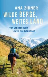 Das Buchcover zeigt eine beeindruckende Berglandschaft mit schneebedeckten Gipfeln im Hintergrund und sattgrünen Hügeln im Vordergrund. Eine Person sitzt auf einem Pferd und reitet durch die weite, offene Landschaft. Der Himmel ist strahlend blau, was eine luftige, entspannte Atmosphäre vermittelt. Der Titel „Wilde Berge, weites Land“ steht in großer, weißer Schrift oben, gefolgt vom Untertitel „Von Ost nach West durch den Kaukasus“ in kleinerer Schrift. Der Autorinnenname „Ana Zirner“ ist ebenfalls prominent platziert.