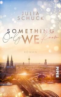 Das Buchcover zeigt eine romantische Stadtansicht von Köln zur Dämmerung, mit einer sanften Farbpalette aus warmen Gold- und Rosatönen. Im Vordergrund sind die charakteristischen Kölner Domtürme und die Hohenzollernbrücke zu sehen. Der Titel „Something Only WE Know“ ist in verschiedenen Schriftarten gestaltet, wobei „WE“ besonders hervorgehoben wird. Der Autorinnenname „Julia Schuck“ steht elegant oben auf dem Cover, während das Wort „Roman“ in kleinerer Schrift unterhalb des Titels platziert ist.