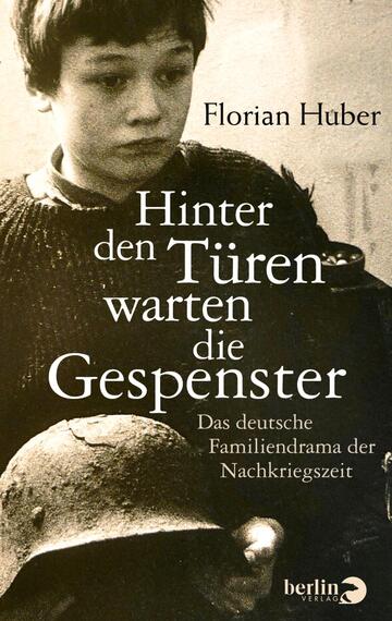 Das Buchcover zeigt ein schwarz-weißes Porträt eines nachdenklichen Jungen, der in einem dunklen Hintergrund steht. Er trägt warme Kleidung und blickt mit ernster Miene in die Ferne. Über dem Bild steht der Titel „Hinter den Türen warten die Gespenster“ in großen, eleganten Schriftzügen, ergänzt durch den Untertitel „Das deutsche Familiedrama der Nachkriegszeit“ in kleinerem, schlichtem Text. Der Autorname „Florian Huber“ ist prominent in der oberen Ecke platziert. Die Atmosphäre des Covers vermittelt Melancholie und nachdenkliche Stimmung.
