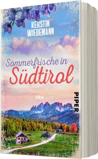 Das Buchcover zeigt eine idyllische Landschaft mit majestätischen Bergen im Hintergrund, die in sanften Blautönen gehalten sind. Im Vordergrund erkennt man eine malerische Almwiese mit bunten Blumen und einem traditionellen Holzhaus. Der Himmel strahlt in warmen Pastellfarben, während die Sonne die Szene sanft beleuchtet. Der Titel „Sommerfrische in Südtirol“ ist in geschwungenen roten Buchstaben prominent platziert, während der Autorenname „Kerstin Wiedemann“ oben in klarem Weiß steht. Das Verlagslogo „PIPER“ ist in der unteren rechten Ecke abgebildet.