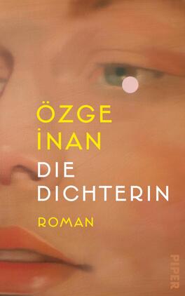 Das Buchcover zeigt ein enges, gemaltes Porträt einer weiblichen Gesichtshälfte in warmen Pfirsich-, Rosen- und Hauttönen, mit einem grünen Auge und einem kleinen rosa Punkt neben dem Auge. Der Autorenname ÖZGE İNAN ist groß in gelber Grotesk gesetzt, der Titel „DIE DICHTERIN“ erscheint in weißer Versal-Grotesk, darunter in gelb das Wort „ROMAN“. Die Stimmung ist intim und malerisch.