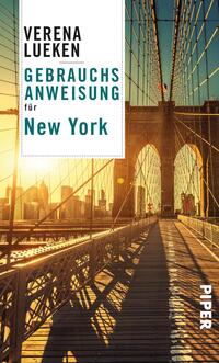 Das Buchcover zeigt eine perspektivisch geführte Ansicht der Brooklyn Bridge bei Sonnenuntergang. Die warmen Farben des Himmels kontrastieren mit den dunkleren Tönen der Brücke. Oben links steht in schwarzer, markanter Schrift „VERENA LUEKEN“, darunter in futuristischer, türkisfarbener Schrift „GEBRAUCHSANWEISUNG für New York“. Das Verlagslogo „PIPER“ befindet sich am rechten Rand in weißer Schrift. Die Gesamtatmosphäre ist einladend und urban.