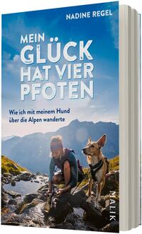 Das Buchcover zeigt eine Frau mit Rucksack, die an einem alpinen Gebirgsbach kniet und Wasser schöpft, rechts neben ihr ein aufmerksamer Hund mit Geschirr. Im Hintergrund blaue Berggipfel unter hellem Himmel. Titel in großen weißen Großbuchstaben: „MEIN GLÜCK HAT VIER PFOTEN“, darunter kleinerer Untertitel: „Wie ich mit meinem Hund über die Alpen wanderte“. Autor oben rechts: Nadine Regel. Atmosphärisch ruhig und naturnah.