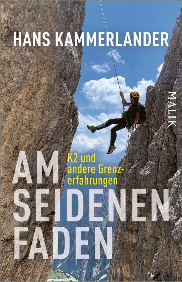 Das Buchcover zeigt eine Person beim Abseilen zwischen steilen, bräunlich-grauen Felswänden vor strahlend blauem Himmel mit weißen Wolken. Oben steht der Autorenname „Hans Kammerlander“ in weißen Großbuchstaben; der Titel „AM SEIDENEN FADEN“ dominiert großflächig in weißer, fetter, serifenloser Schrift; die gelbe Unterzeile „K2 und andere Grenzerfahrungen“ ist kleiner. Der Kletterer trägt einen gelben Helm, Gurt und ein Seil, die Szene wirkt spannungsreich und luftig.