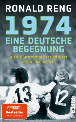 Das Buchcover zeigt eine schwarz-weiße Fotografie von zwei Fußballspielern, die im Hintergrund auf dem Rasen sitzen. Die beiden Spieler tragen Trikots mit der Nummer 12 und 13. Oben auf dem Cover befindet sich der Titel „1974 EINE DEUTSCHE BEGEGNUNG“ in großen, türkisfarbenen Buchstaben. Darunter steht der Autor „RONALD RENG“ in einer schmaleren Schrift. Am unteren Rand ist der Zusatz „SPIGEL Bestseller“ in gelben Buchstaben auf rotem Hintergrund zu sehen, gefolgt von „Jetzt als Taschenbuch“ in kleinerer Schrift.