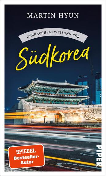 Das Buchcover zeigt eine nächtliche Stadtansicht mit dem historischen Eingangsportal Gwanghwamun in Südkorea, das von modernen Wolkenkratzern umgeben ist. Der Hintergrund ist in dunklen Blautönen gehalten, während das Tor in hellen Grautönen und mit feinen Details leuchtet. Der Titel „Südkorea“ ist in auffallendem Gelb geschrieben, während der Untertitel „Gebrauchsanweisung für“ in Weiß darüber steht. Oben steht der Autorennamen „Martin Hyun“ in einer eleganten, modernen Schrift. Unten links befindet sich ein rotes Feld mit dem Text „SPIEGEL Bestseller-Autor“.