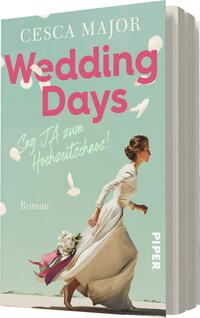 Das Buchcover zeigt eine Frau in einem eleganten, weißen Hochzeitskleid, die mit einem Strauß Blumen in der Hand vorwärts läuft. Der Hintergrund ist in sanftem Türkis gehalten und wird von fliegenden weißen Blütenblättern geschmückt. Der Titel „Wedding Days“ ist in großen, pinken Buchstaben oben auf dem Cover platziert. Darunter steht in freundlicher, handschriftlicher Schrift „Sag JA zum Hochzeitschaos!“. Am unteren Rand steht das Wort „Roman“ sowie das Verlagslogo „PIPER“.