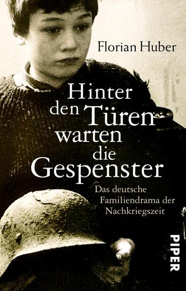 Das Buchcover zeigt ein eindringliches, schwarz-weißes Bild eines Jungen, der nachdenklich in die Kamera blickt. In der oberen Hälfte steht der Titel „Hinter den Türen warten die Gespenster“ in auffälliger, kontrastreicher Schrift, während der Untertitel „Das deutsche Familiendrama der Nachkriegszeit“ in kleinerer Schrift darunter platziert ist. Der Autorenname „Florian Huber“ ist oben links angebracht. Die düstere Atmosphäre des Covers vermittelt die Thematik des Buches.