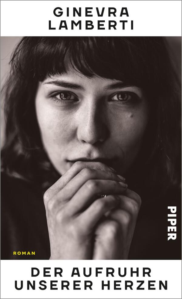 Das Buchcover zeigt das Porträt einer Frau mit dunklem Haar und einem nachdenklichen Ausdruck. Ihr Gesicht ist großflächig in Schwarz-Weiß gehalten, während ihre Hände in einer nachdenklichen Pose vor ihrem Mund liegen. Der Titel „DER AUFRUHR UNSERER HERZEN“ ist in kräftigen, weißen Buchstaben am unteren Rand platziert. Der Name der Autorin, „GINEVRA LAMBERTI“, befindet sich oben und ist in starkem Schwarz hervorgehoben. Das Cover vermittelt eine Atmosphäre von Introspektivität und emotionaler Tiefe.