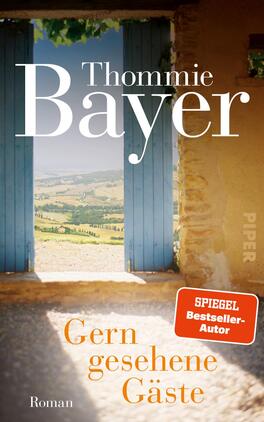 Das Buchcover zeigt eine offene blaue Tür, die den Blick auf eine hügelige Landschaft freigibt. Die Farben sind warm und einladend, mit sanften Erdtönen und einem strahlend blauen Himmel. Der Titel „Gern gesehene Gäste“ ist in orangefarbener Schrift platziert, während der Autorenname „Thommie Bayer“ in elegantem Weiß hervorsticht. In der oberen rechten Ecke befindet sich ein rotes Etikett mit dem Text „SPIEGEL Bestseller-Autor“. Die Atmosphäre wirkt freundlich und dromerisch.