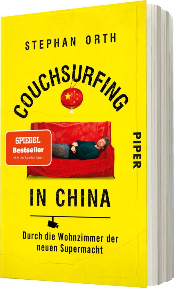 Das Buchcover zeigt einen gelben Hintergrund mit dem Titel „Couchsurfing in China“ in großen, schwarzen Buchstaben. Darunter steht der Untertitel „Durch die Wohnzimmer der neuen Supermacht“ in einer kleineren, schwarzen Schrift. In der oberen Hälfte des Covers ist der Autor „Stephan Orth“ abgebildet. Er sitzt entspannt auf einer roten Couch. Über ihm schwebt eine rote Laterne mit dem chinesischen Sternenbanner. Unten links befindet sich ein rotes Feld mit dem Text „SPIEGEL Bestseller – Jetzt als Taschenbuch“.
