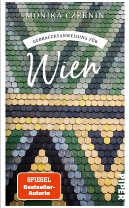 Das Buchcover zeigt ein farbenfrohes, mosaikartiges Dachmuster in Grüntönen, Beige, Braun und Blau. Am oberen Rand steht in einer geschwungenen Schrift „Gebrauchsanweisung für“ und darunter in einer großen, markanten Schrift „Wien“. Der Name der Autorin, Monika Czernin, erscheint in größerer Schrift im oberen Bereich. In der unteren rechten Ecke ist ein rotes, rechteckiges Feld mit dem Text „SPIEGEL Bestseller-Autorin“ platziert. Die Gesamtatmosphäre vermittelt eine einladende und informative Stimmung.