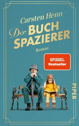 Das Buchcover zeigt auf einem teal-farbenen Hintergrund einen älteren Mann in einem dunkelblauen Mantel mit einem Hut und einem Regenschirm, der auf einer Parkbank sitzt. Neben ihm sitzt ein kleines Mädchen in einem rot-gelben Outfit, das ihn aufmerksam ansieht. Der Titel „Der BUCHSPAZIERER“ ist in großen goldenen Buchstaben angezeigt, darüber steht der Name des Autors „Carsten Henn“. Der Schriftzug „SPIEGEL Bestseller“ in einem roten Kästchen ist ebenfalls prominent platziert. Der Verlag „PIPER“ ist in heller Schrift am rechten Rand zu sehen.