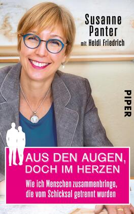 Das Buchcover zeigt eine lächelnde Frau mit blonden, schulterlangen Haaren und einer Brille, die in einem hellen Raum sitzt. Der Titel „AUS DEN AUGEN, DOCH IM HERZEN“ ist in großen, pinken Buchstaben auf einem weißen Hintergrund platziert. Darunter steht der Untertitel „Wie ich Menschen zusammenbringe, die vom Schicksal getrennt wurden“ in kleinerer Schrift. Am rechten Rand ist der Verlagsname „PIPER“ in schlichter, schwarzer Schrift zu sehen. Die gesamte Atmosphäre des Covers vermittelt Offenheit und Herzlichkeit.