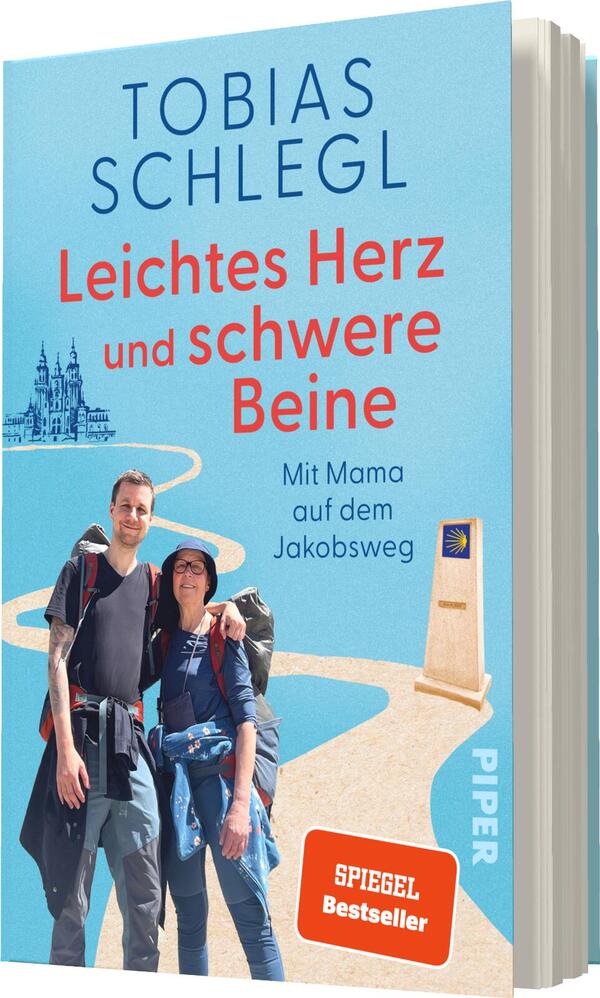 Das Buchcover zeigt ein hellblaues Design mit einer Illustration eines symbolischen Weges, der sich durch die Landschaft schlängelt. Oben steht der Titel „Leichtes Herz und schwere Beine“ in großer, roter Schrift. Darunter sind die Worte „Mit Mama auf dem Jakobsweg“ in kleinerer Schrift. Im Vordergrund sind zwei Personen abgebildet, die Wanderausrüstung tragen und sich freundlich umarmen. Links im Hintergrund sind stilisierte Gebäude zu sehen. Das Cover enthält das „SPIEGEL Bestseller“-Logo.