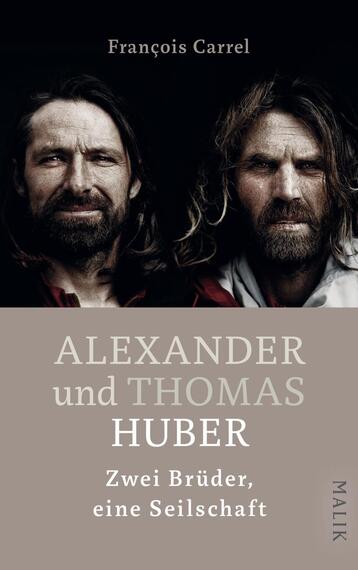 Das Buchcover zeigt zwei Männer mit langen Haaren und Bärten, die sich frontal gegenüberstehen. Die Farbgebung ist dunkel, mit einem grauen Hintergrund, der die Gesichter betont. Der Titel „ALEXANDER und THOMAS HUBER“ ist in großen, auffälligen Buchstaben in Weißformatiert, während der Untertitel „Zwei Brüder, eine Seilschaft“ in kleinerer Schriftgröße darunter steht. Der Name des Autors, François Carrel, befindet sich oben, ebenfalls in Weiß. Die Atmosphäre wirkt kraftvoll und entschlossen.